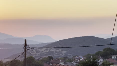 helicopter in the distance, evening with smoke in sky in greece