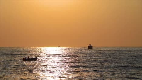 boats passing the scenic natural landscape at sunset