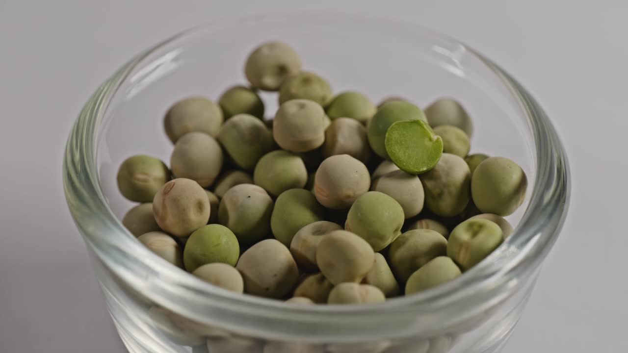 dried green peas in small glass bowl, 4k, parallax shot.