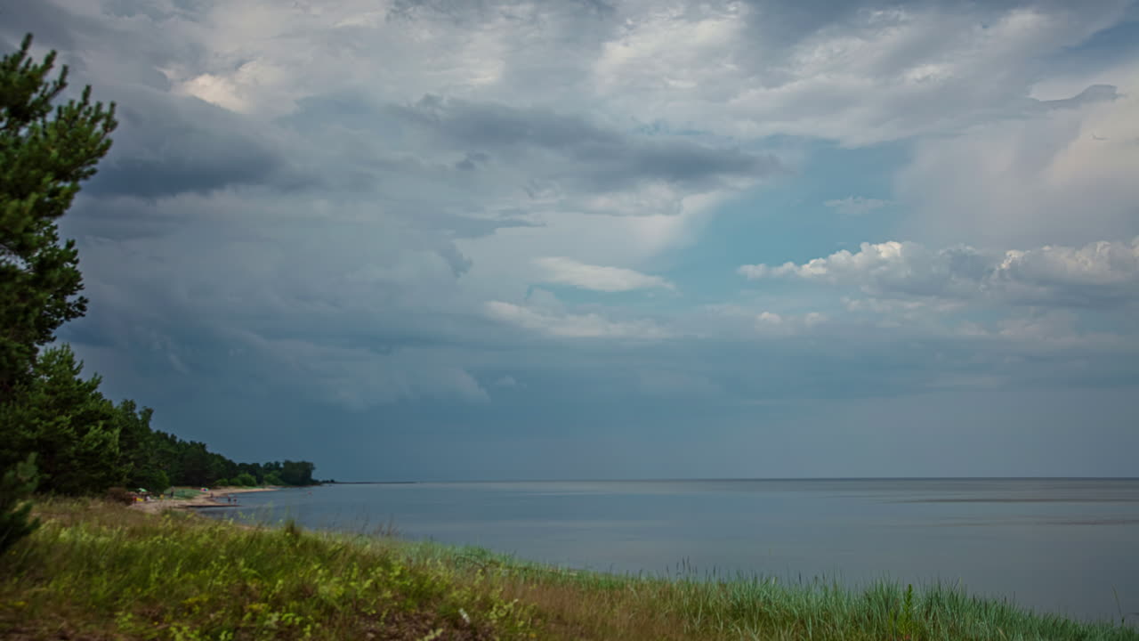 바다 해안을 따라 잔잔한 해변 위에 흐린 클라우드스케이프 - 시간 경과