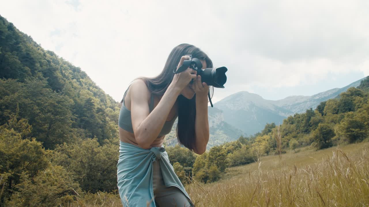 Donna viaggiatrice che fotografa il suo cane durante un viaggio in montagna, un'avventura estiva.