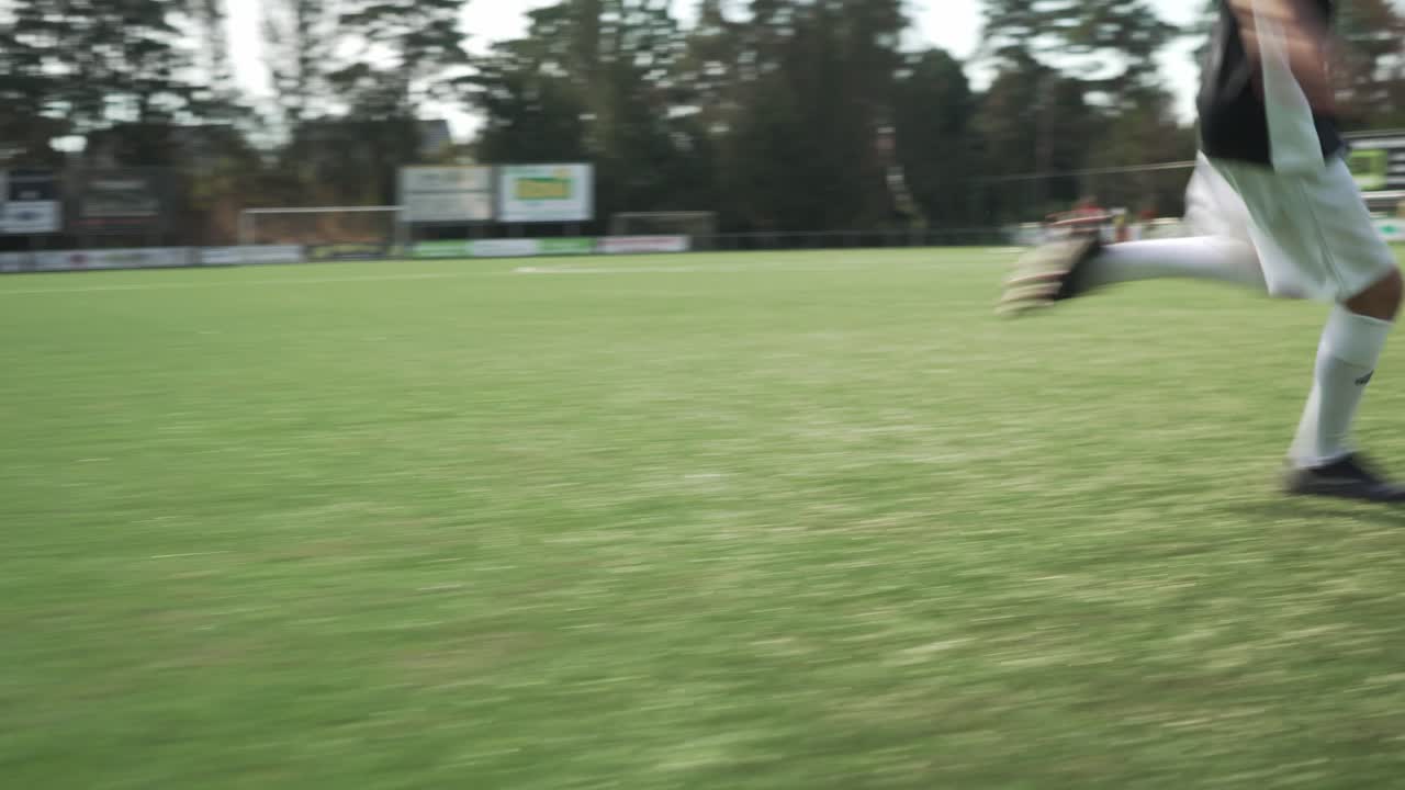 Young soccer player dribbling the ball really fast.