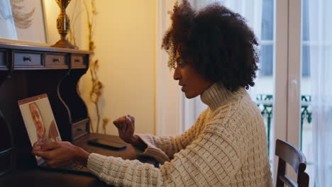 Positive-woman-calling-laptop-at-home-close-up.-African-lady-talking-video-call