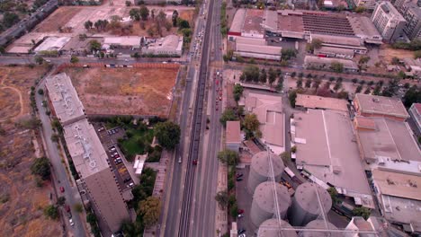 Aerial-view-following-a-long-metro-train,-colorful-evening-in-Santiago-de-Chile