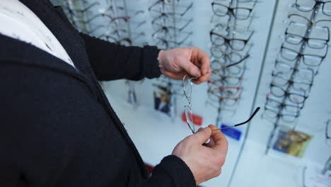client choosing lenses in store. young male patient testing and trying new glasses