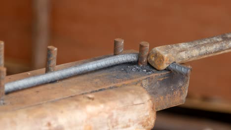 worker bending steel for construction job