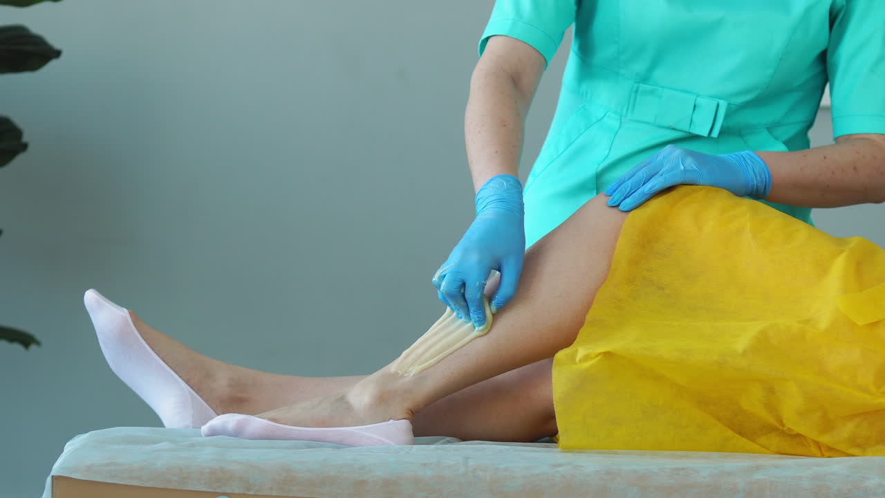 primer plano de la mano del maestro de la depilación eliminar pequeños pelos con una técnica especial de azúcar haciendo sacudidas afiladas con la mano