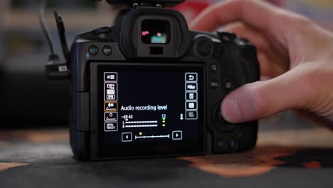 photographer's hand pressing button and adjusting the settings of a camera