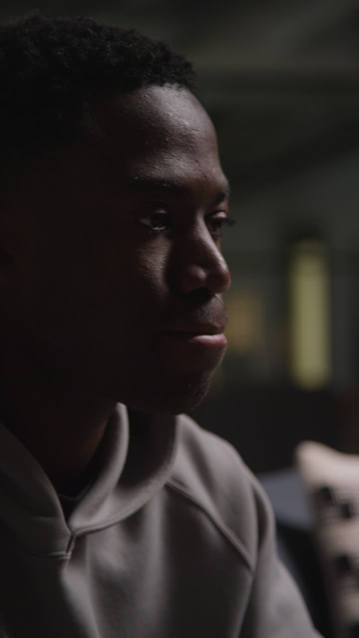 Vertical Video Close Up Shot Of Unhappy And Depressed Young Man Sitting On Sofa Shaking Head And Shouting 2