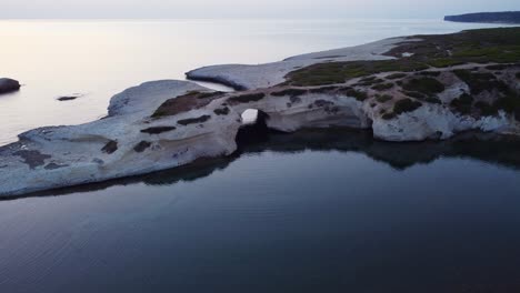 Famous Sardinian arch coast rock formation, S&#039;Archittu, aerial view, sunset