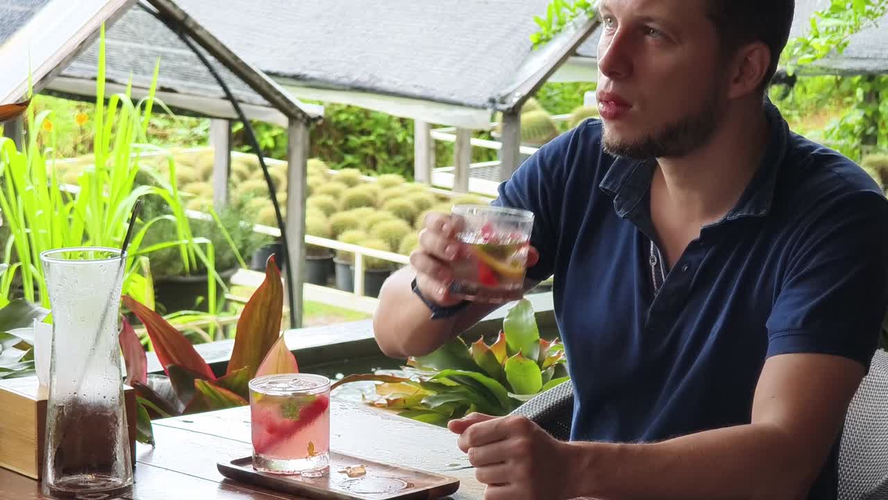 hombre disfrutando de una bebida refrescante en un café de jardín