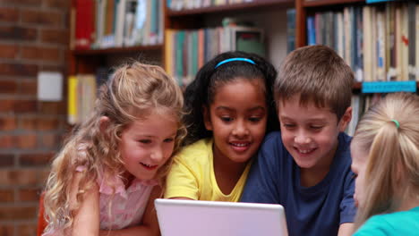 alumnos que usan el tablet juntos en la biblioteca