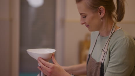 happy woman working in kitchen grinding meat