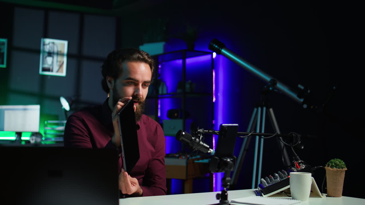 테크 전문가는 태블릿을 소개하고 스마트폰으로 촬영합니다.