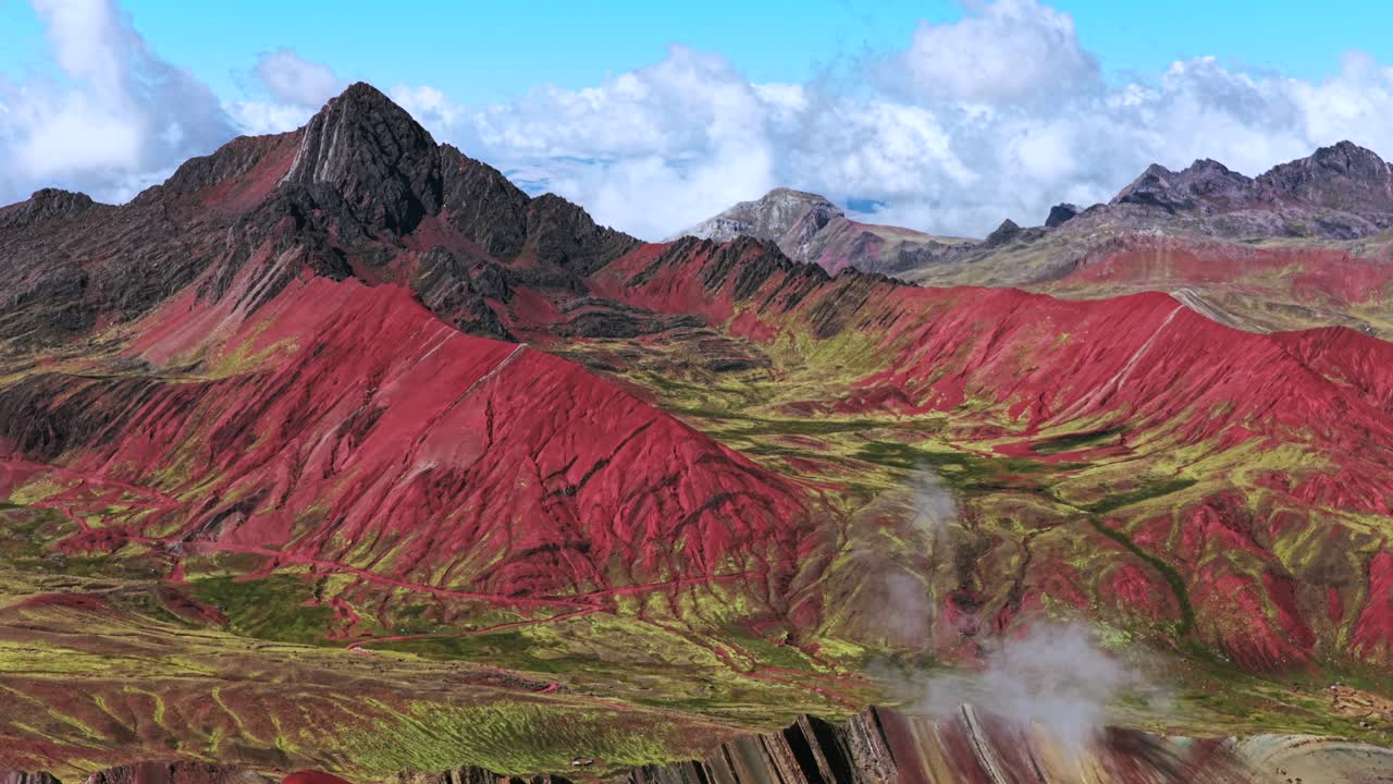 Escursione alla Montagna Arcobaleno della Valle Rossa, Vinicunca Montaña de Siete Colores, Perù, vista aerea da drone delle Ande peruviane, montagne dei sette colori, ghiacciaio sciolto, Vilcanota, regione di Cusco, cielo blu mattutino, panoramica all'indietro verso l'alto