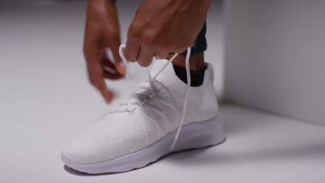 Close-Up-Of-Female-Athlete-In-Gym-Or-Changing-Room-Tying-Laces-Of-Training-Shoe-Before-Exercising-3