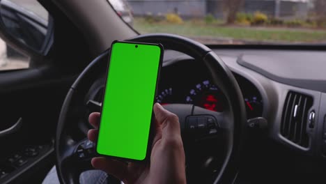 el uso del teléfono mientras se conduce en el coche. teléfono con una pantalla verde para su inscripción. espacio de copia en su teléfono