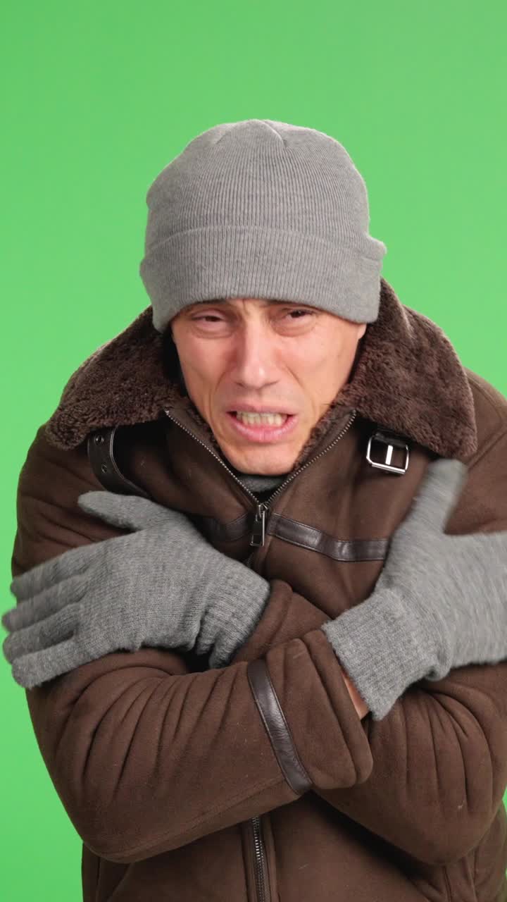 Man shivering and freezing on green screen background