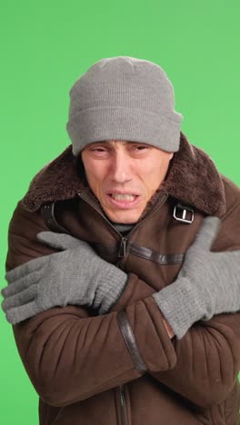 Man shivering and freezing on green screen background