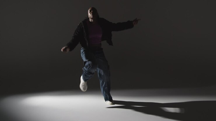 Full Length Studio Portrait Shot Of Young Woman Dancing With Low Key Lighting Against Grey Background 6