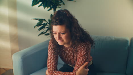 a distraught woman on a blue therapy office sofa fianlly opening up and starts crying. ideal for mental health awareness campaigns, counseling resources, and dramatic storytelling