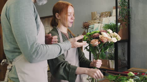 pretty florist arranging flowers in bouquet