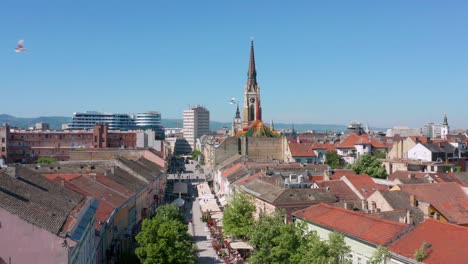 mercado callejero y edificios de la ciudad con el nombre de la iglesia de maría en novi sad, serbia