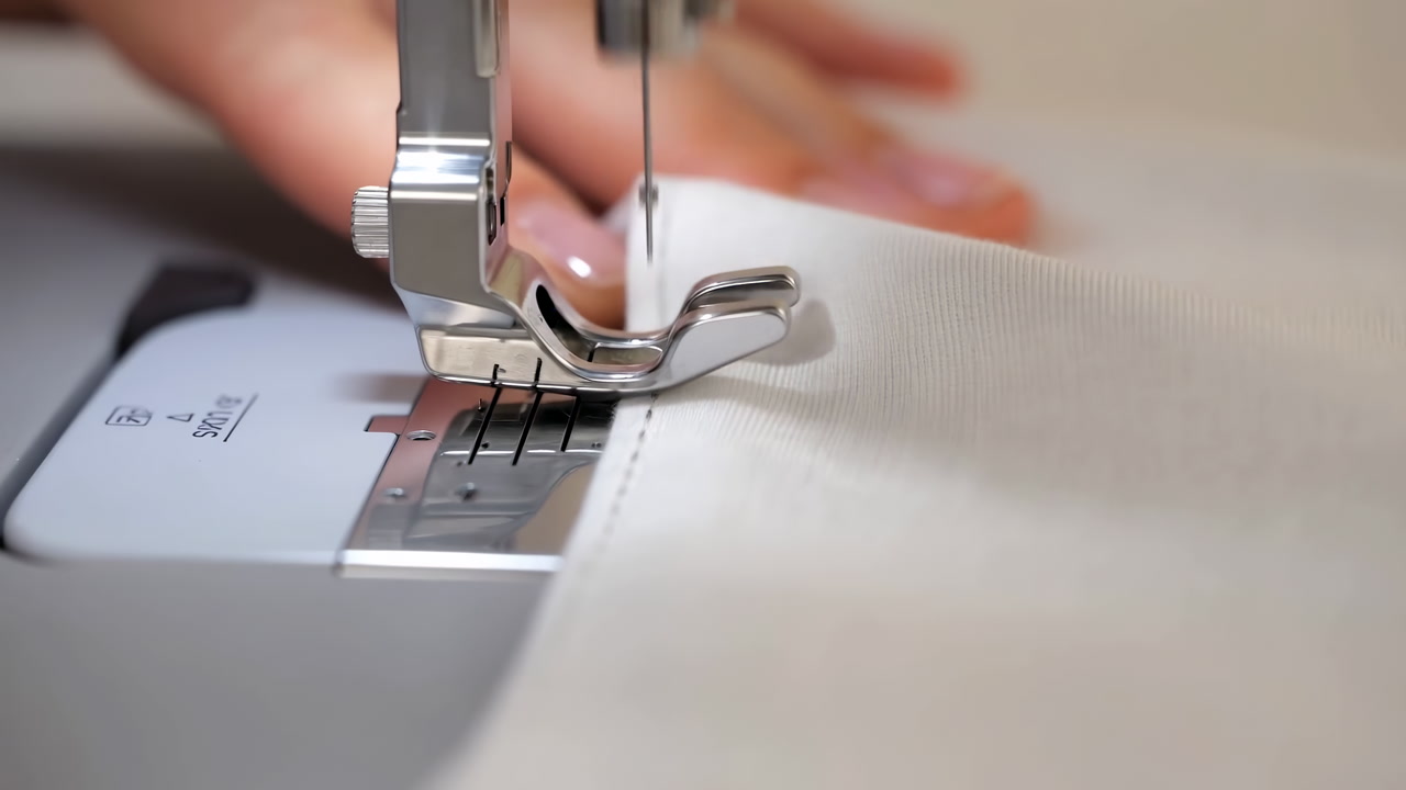 Closeup Sewing Machine Foot Stitching Fabric, Tailor Hands Guiding Delicate White Textile Under Needle, Smooth