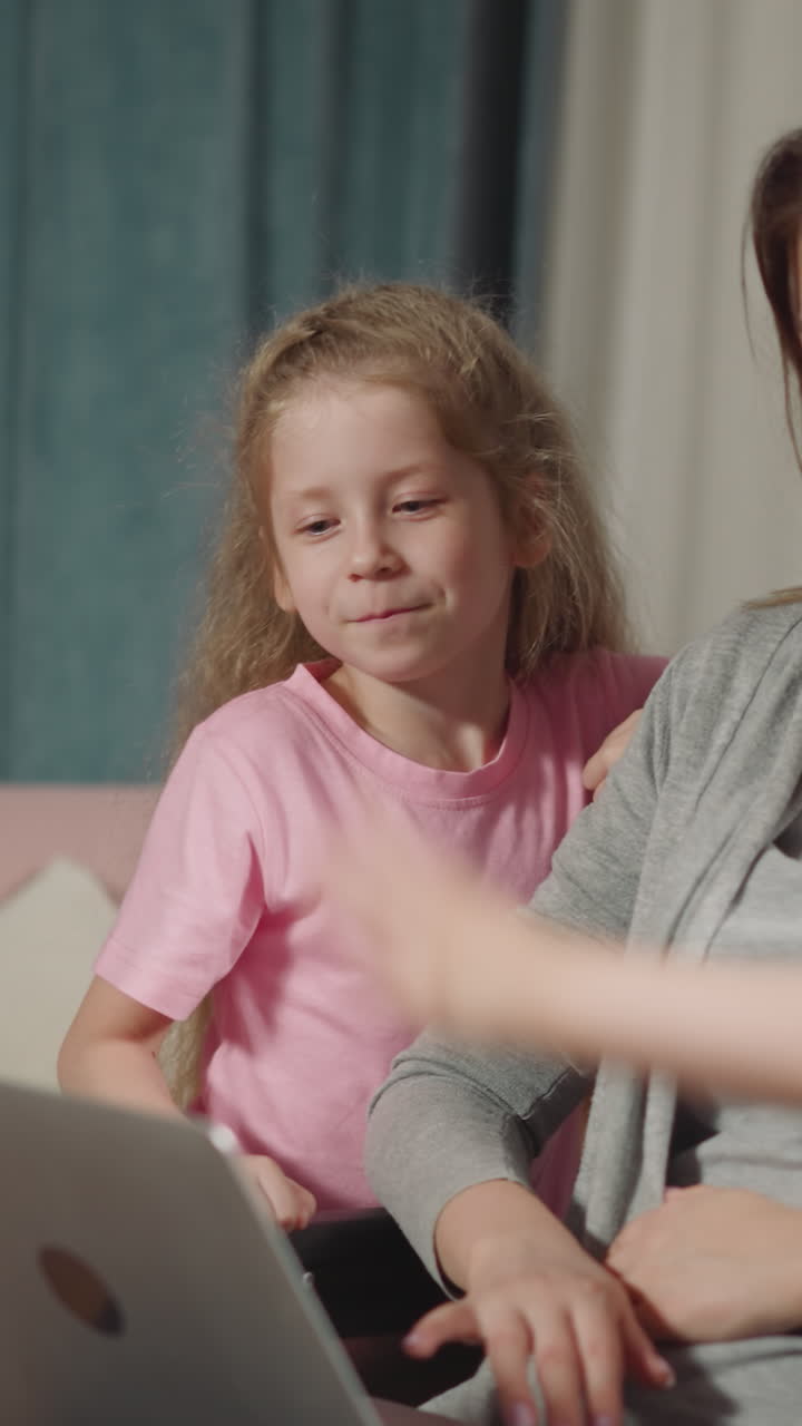 un preescolar curioso y un niño pequeño miran a su mamá usando un aparato moderno en casa. una mujer joven en silla de ruedas y los niños sonríen mirando el portátil de cerca