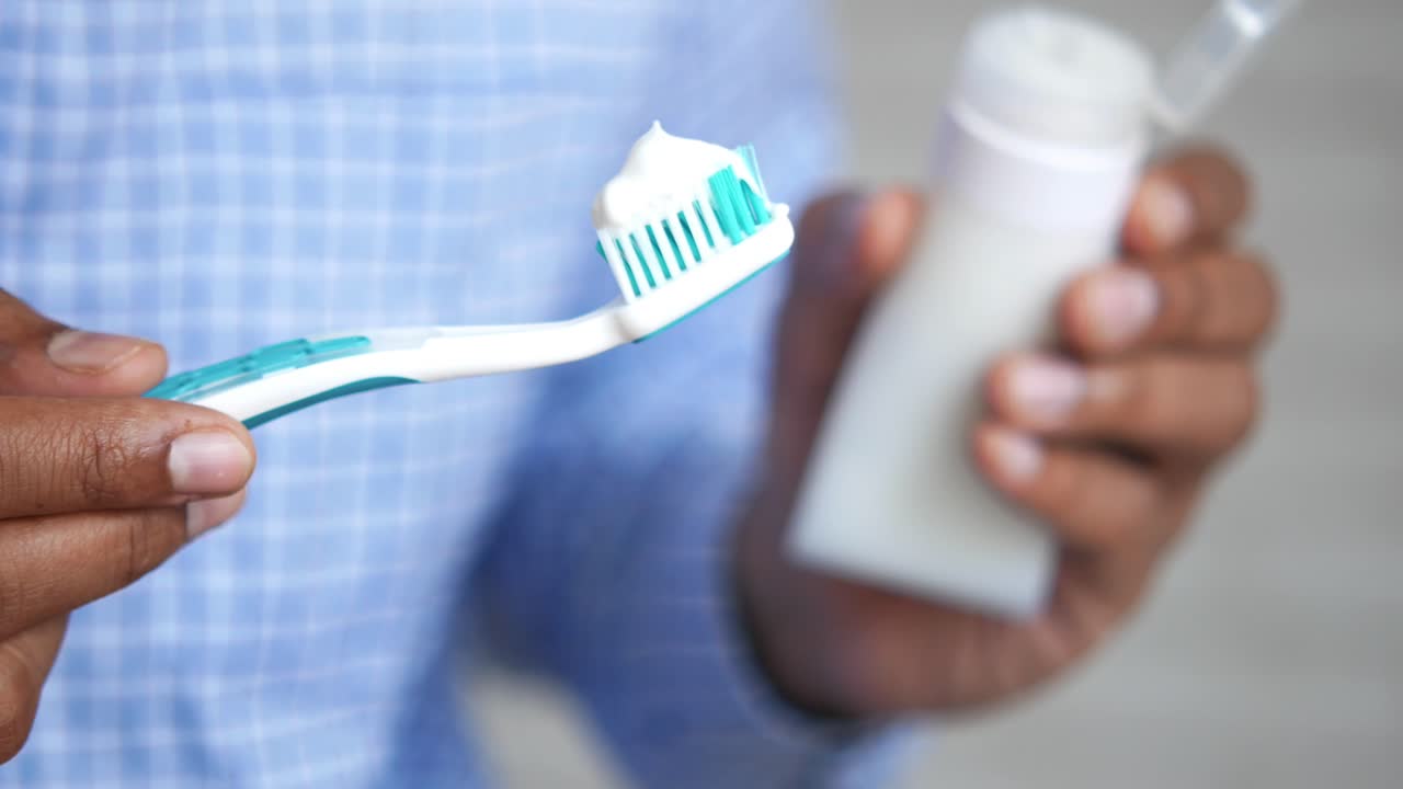 Person holding a toothbrush and toothpaste