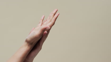de manos de mujer asiática en fondo beige con espacio de copia, cámara lenta