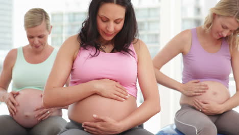 pregnant women doing yoga in fitness studio