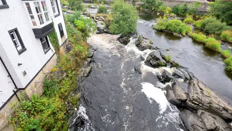 flowing stream beside buildings in llangollen, wales