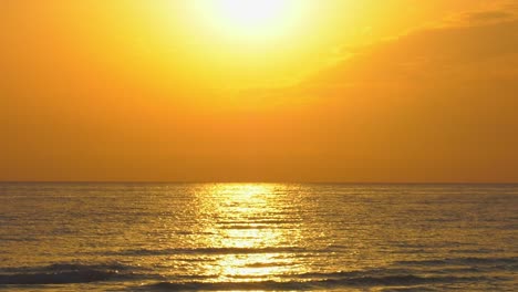 Golden-sea-reflecting-sun-rising-in-orange-sky