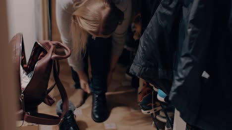 woman putting on boots before going out