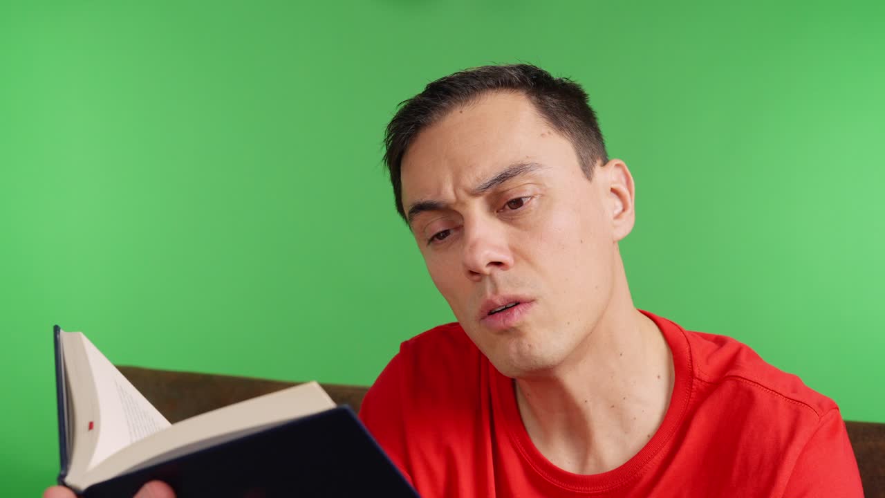 Man reading a book on a sofa with green screen background