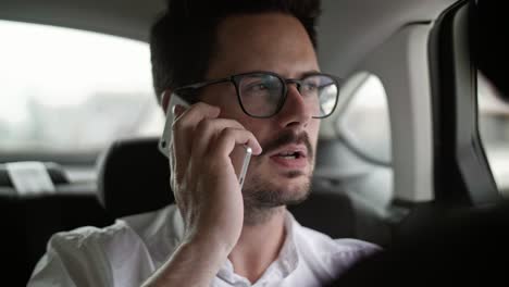 hombre usando un teléfono móvil en un taxi