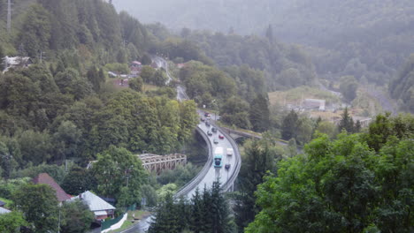 4k timelapse tráfico de automóviles en sinaia senrise, paisaje de montaña, automóviles, vías, tren, montañas verdes se elevan por encima de la calma, rumania