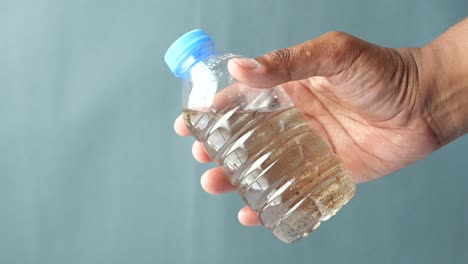 hand holding a dirty water bottle