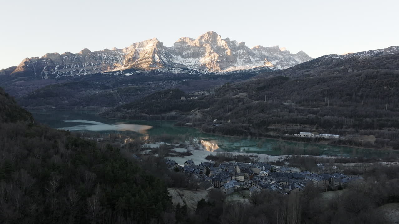 Winter Mountain Village with Lake and Snowy Peaks