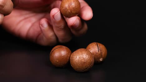 recoger a mano las nueces de macadamia de una superficie