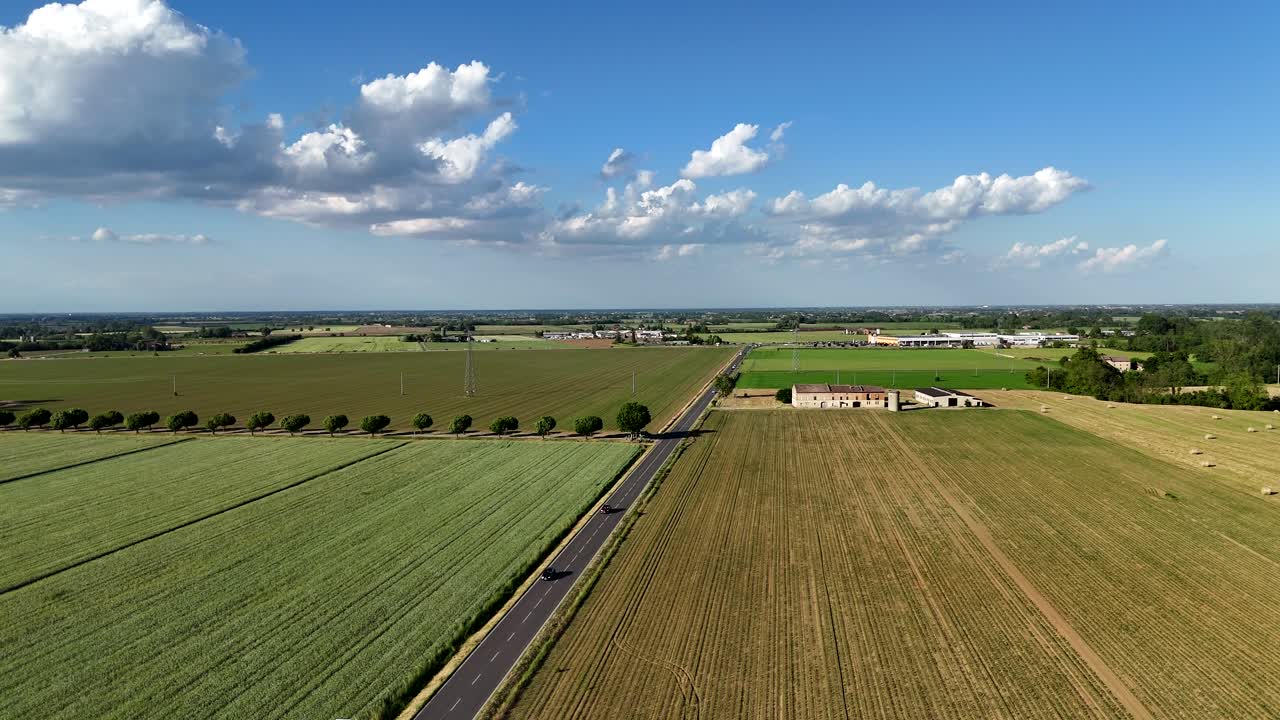Drone flyver over ensartede rækker af kornmarker – sandsynligvis hvede eller majs – og nærliggende grøntsagsmarker, sukkermajs eller industritomater, i landskabet omkring Alseno, Piacenza, Norditalien.