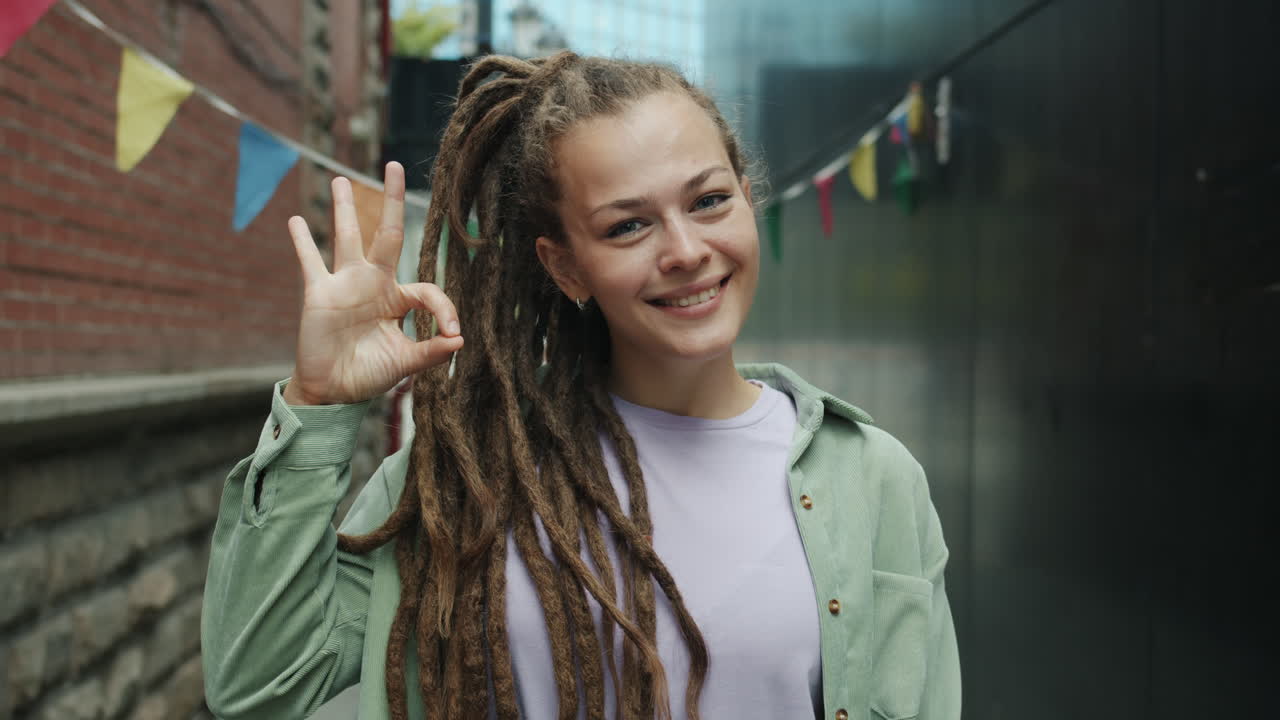 Smiling Woman with Dreadlocks in Urban Alley