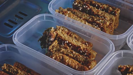 baked mix vegetable snack bars topped with sesame seeds on a rectangle plastic container