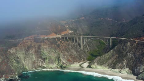 Vista-Aérea-Del-Impresionante-Puente-Bixby-Creek-En-El-Brumoso-Día-De-Big-Sur-California