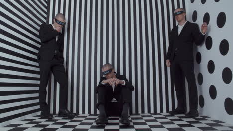 blindfolded men in a black and white studio
