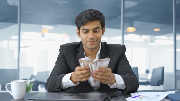 empresario indio contando dinero con una sonrisa astuta
