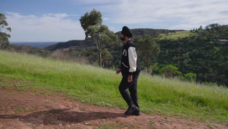 hombre indio punjabi sikh caminando por la pendiente con vistas panorámicas a la montaña en un día soleado