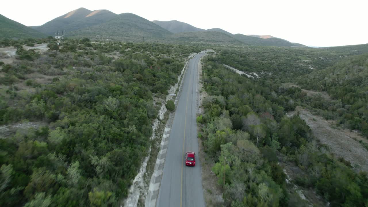 AÉREA - Carro descendo uma estrada na colina, Tamaulipas, México, plano frontal amplo