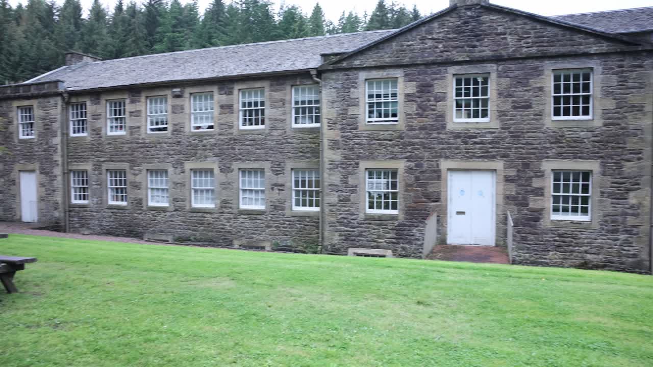 Slow panning shot of antique buildings at the UNESCO site in New lanark